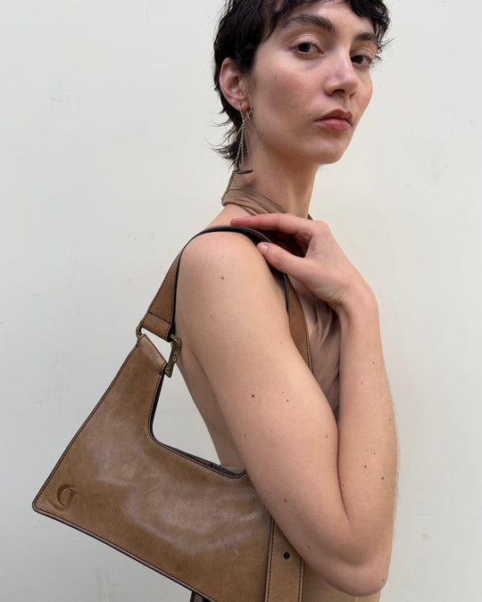 Woman holding a brown leather handbag