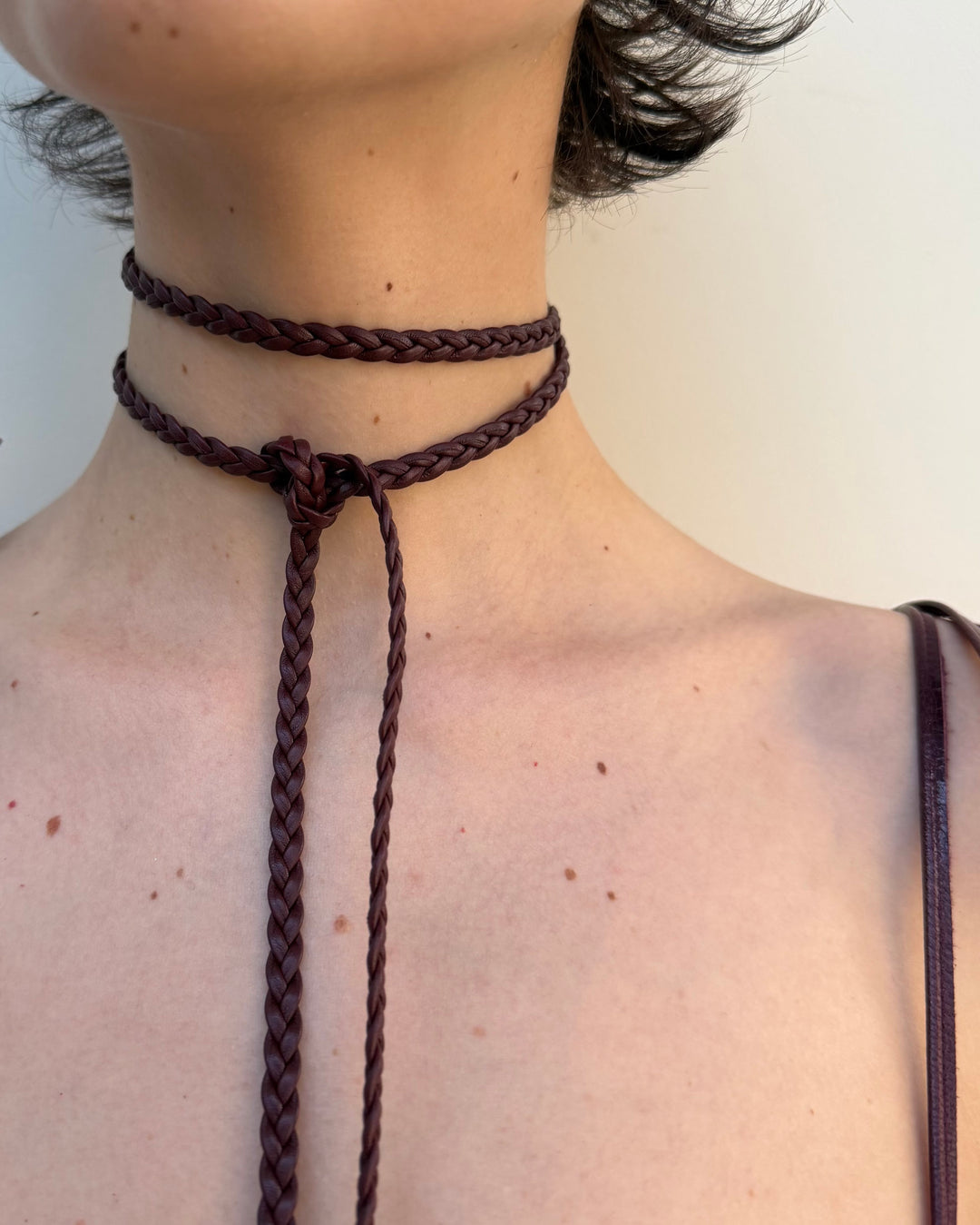 Detail of a braided leather necklace on girl