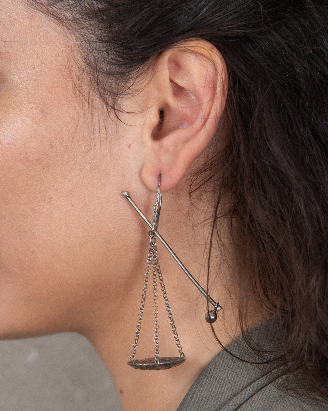 Close up of the handmade silver statement earring showing the fine chain and intricate yet minimal design.