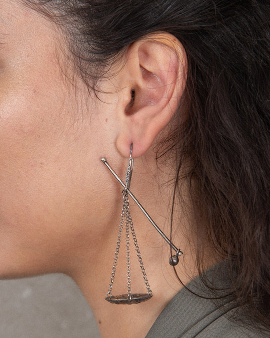Close up of the handmade silver statement earring showing the fine chain and intricate yet minimal design.