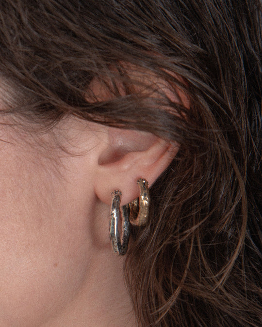 A bronze small hoop and a silver bigger one creating a simple yet unique styling