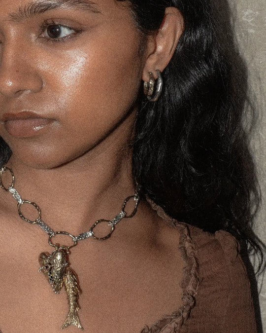 woman wearing a bold combination of jewellery in mixed metals