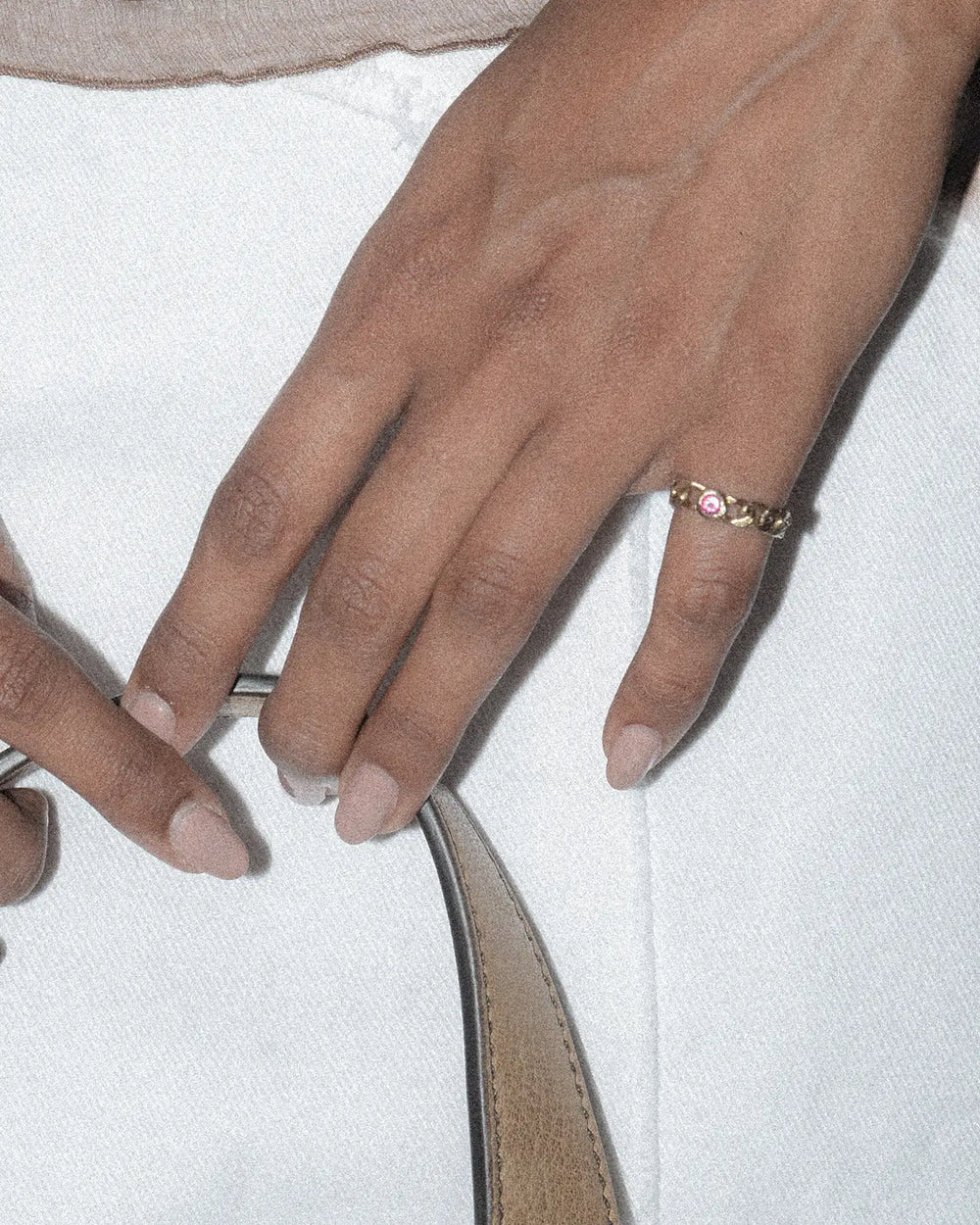 bronze chain ring with pink stone styled on the pinky finger
