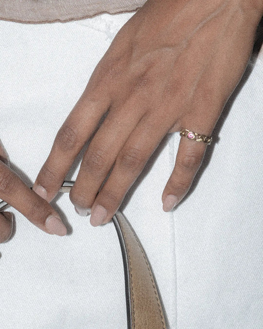 bronze chain ring with pink stone styled on the pinky finger