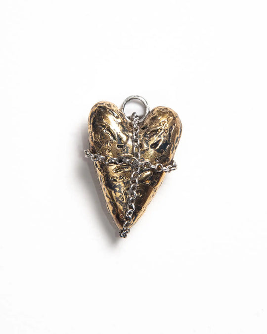Back side of a bronze heart-shaped charm with a textured finish, revealing the intricate cross chain pattern on the reverse, showcasing the detailed craftsmanship and layered design of the jewelry.