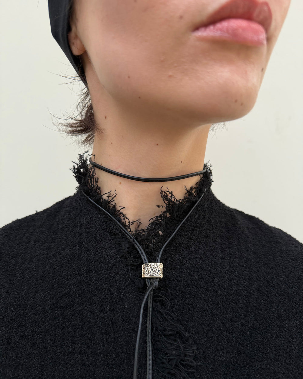 Woman wearing a black lace choker with a decorative pendant