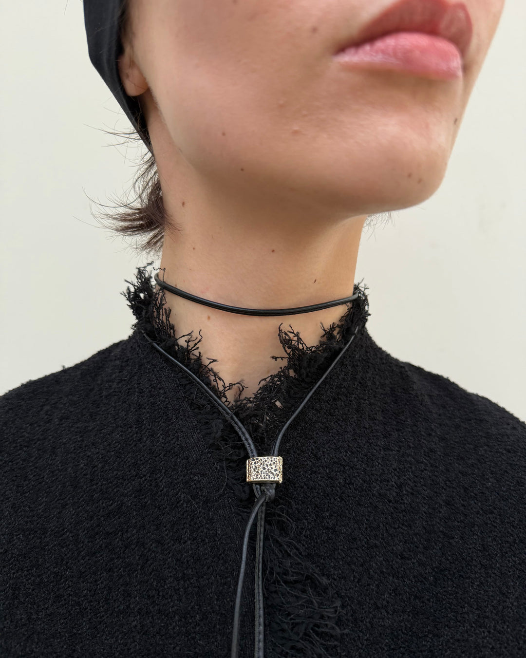 Woman wearing a black lace choker with a decorative pendant