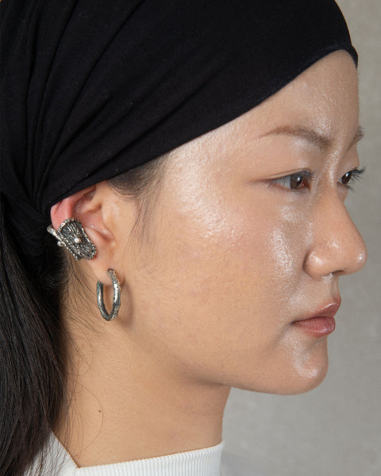 A fashionable combination of a minimalist and unique earrings, highlighting contemporary style and intricate craftsmanship.