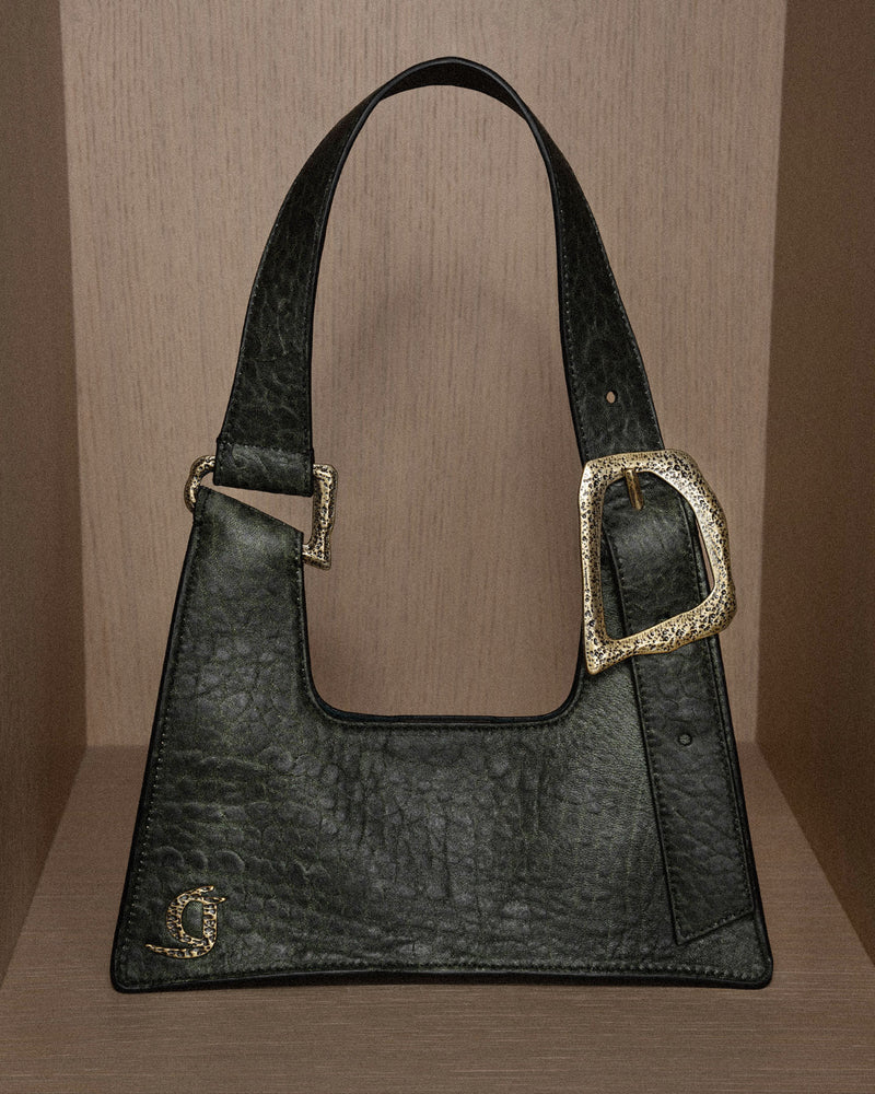 Still photo of the GIGI BAG MOSS CROCODILE showcasing its chic moss-green color and bronze metal buckle and accents, highlighting the luxurious texture and craftsmanship.