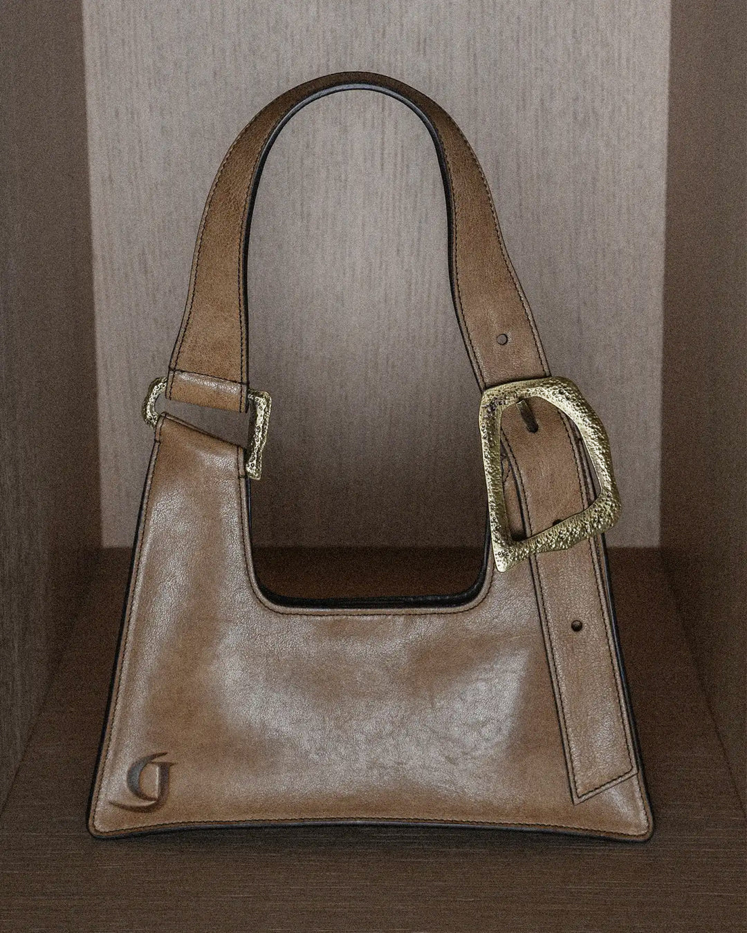 A stylish vintage-style handbag in warm tobacco hue with a rich, textured surface. The bag features classic detailing and a timeless design, perfect for adding a touch of retro sophistication to any outfit. Its aged finish and vintage texture evoke a sense of timeless elegance and effortless charm.