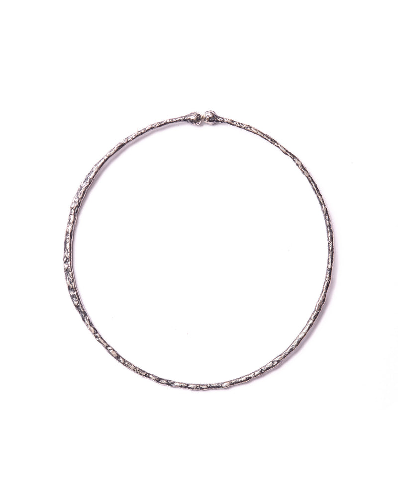 Close-up of the large silver ear cuff, showcasing their handcrafted organic textures and sleek, sophisticated design