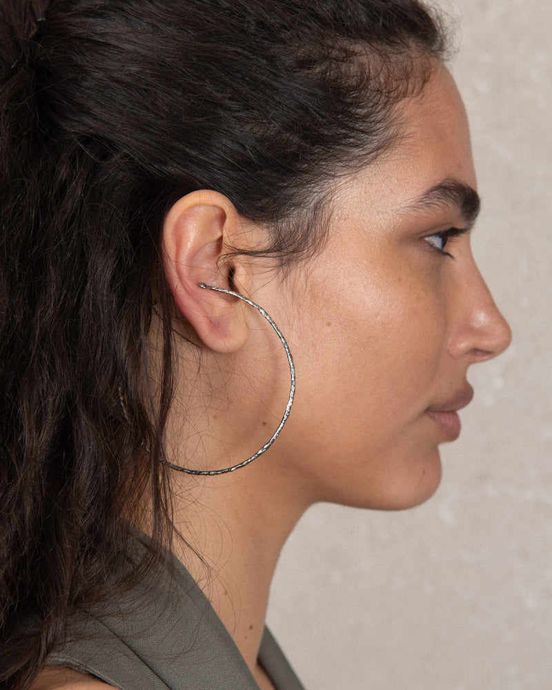 Elegant large silver ear cuff with handcrafted organic textures and a sleek, refined design that enhances your sophisticated style