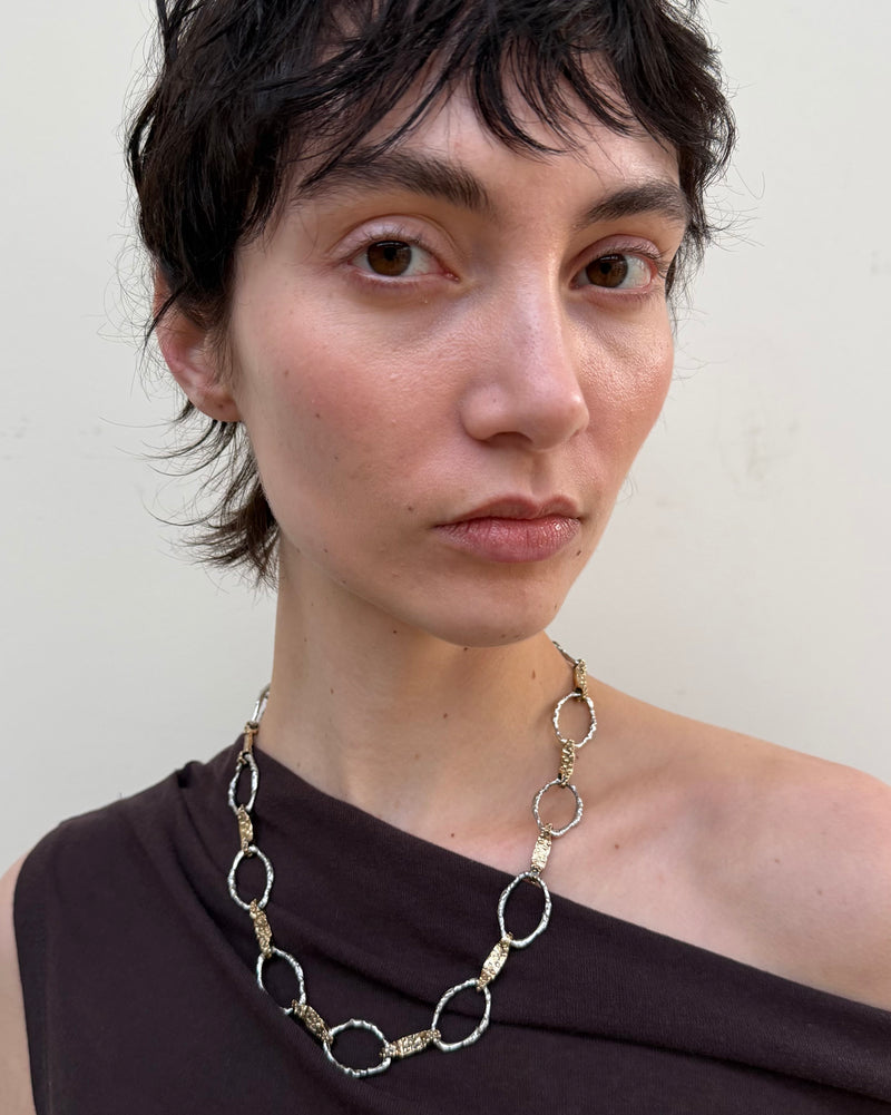 Woman wearing a long, intricate necklace