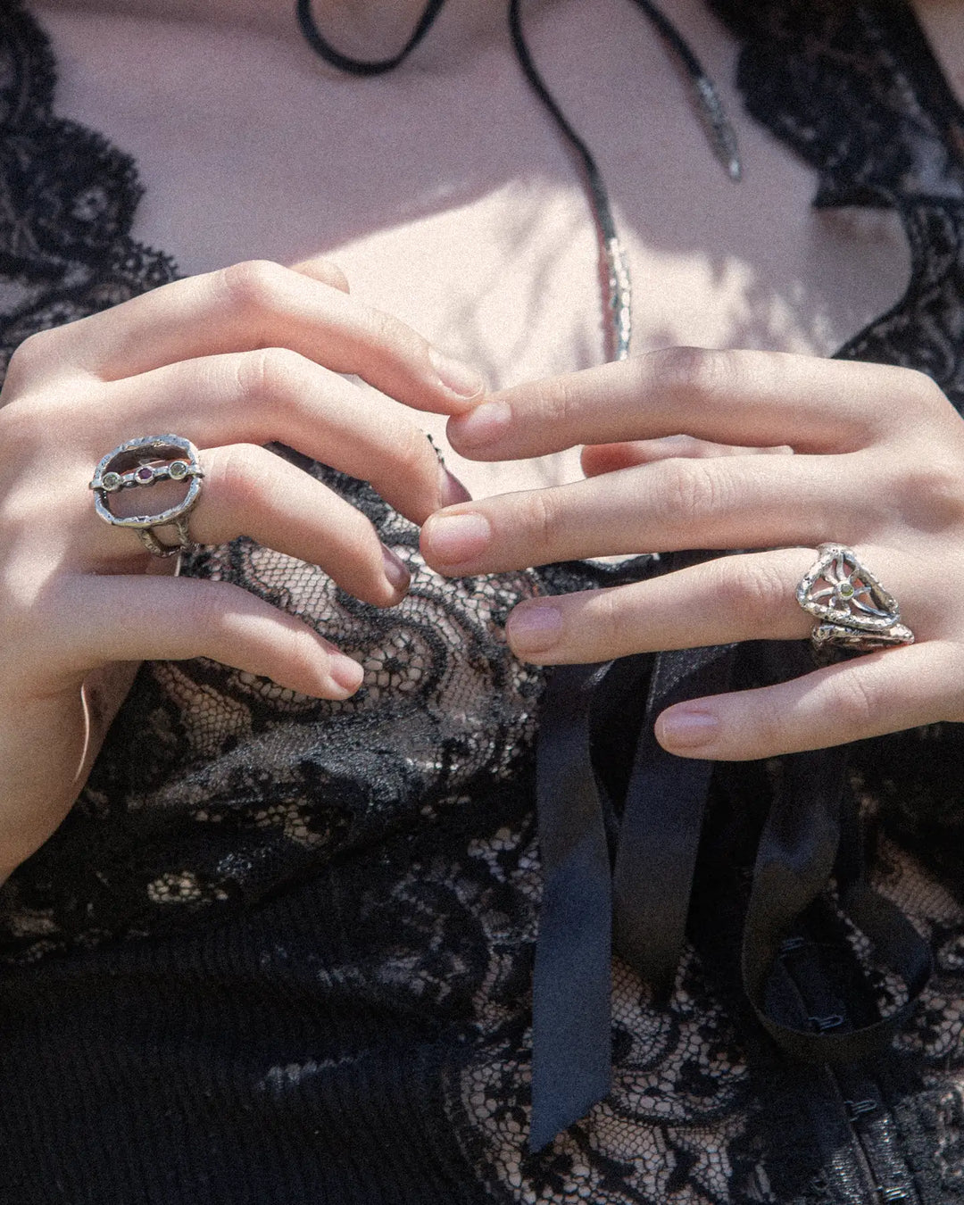 Elegant woman wearing silver rings with colourful gemstones 