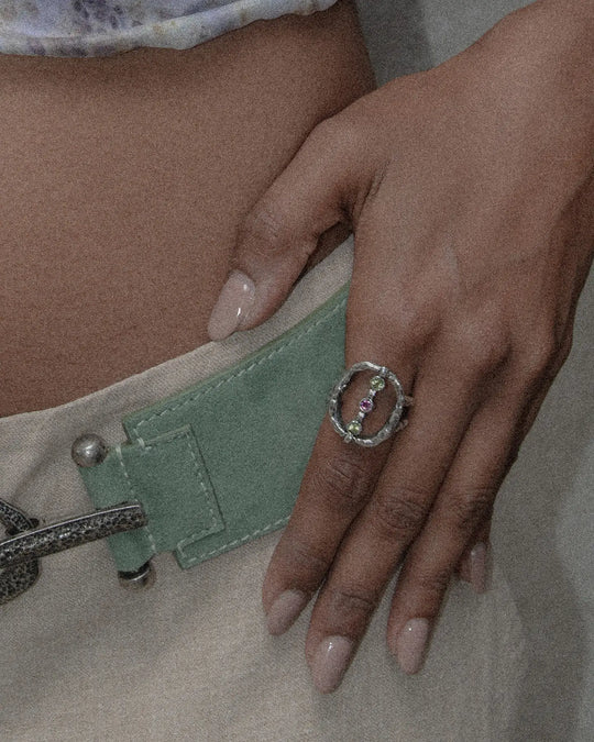 Ring with an oval silhouette and a row of three stones set vertically