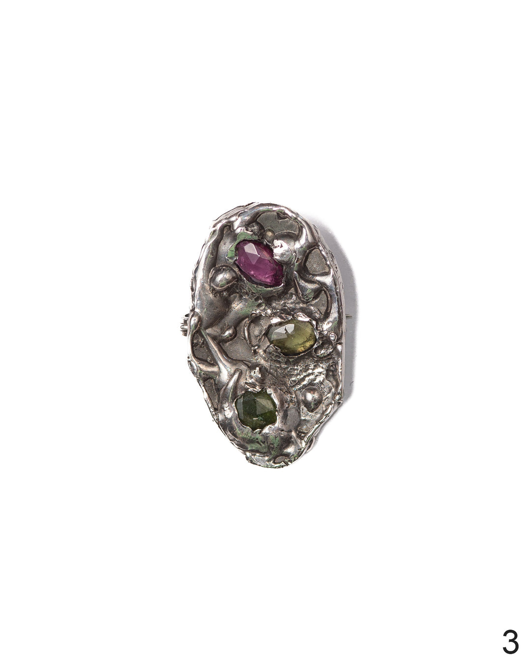 Handcrafted silver brooch with textured detailing and earthy coloured stones