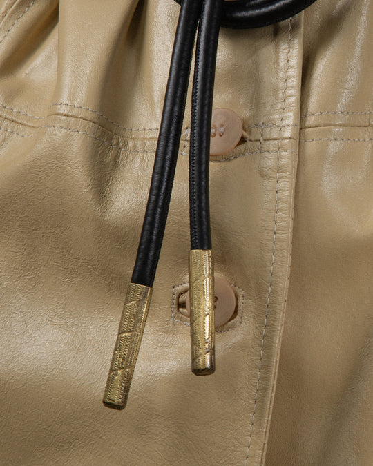 A close-up shot of the bronze metal details on the belt, highlighting the textured finish. The focus is on the intricate surface texture, showcasing the beauty of the craftsmanship
