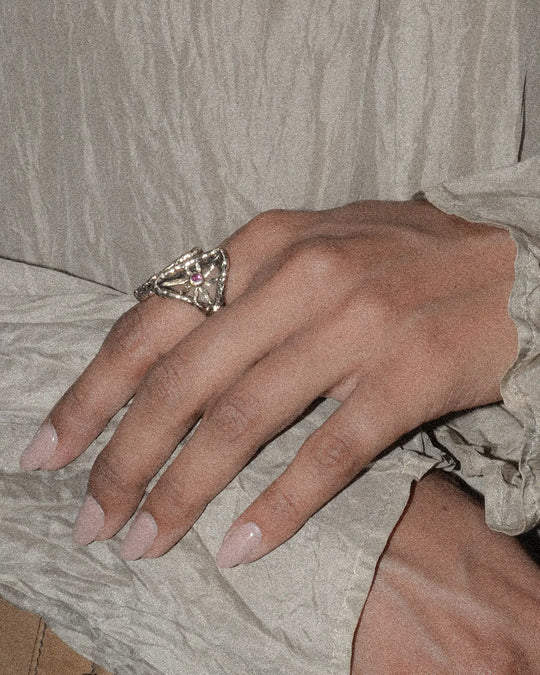Elegant woman wearing a bronze ring with pink stone resembling the sun