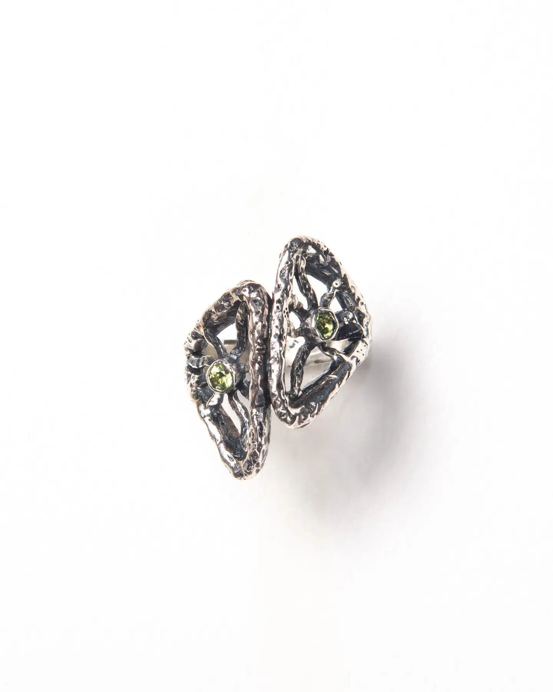 A silver ring with a textured finish and natural green stones framed by metal rays