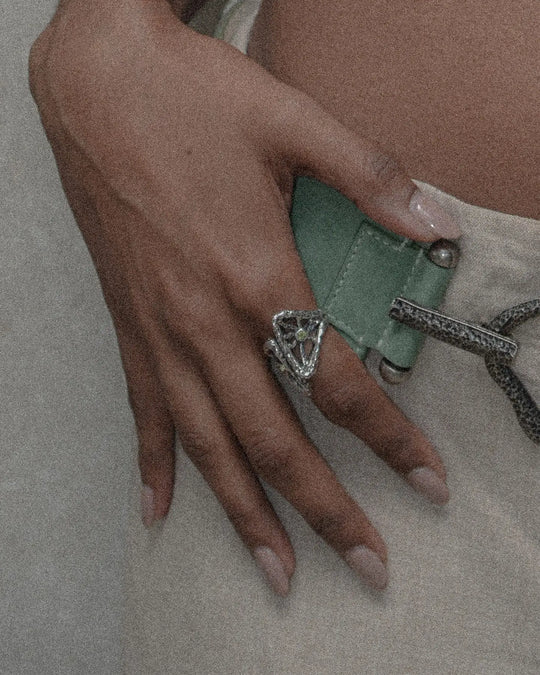 Elegant woman wearing silver ring with framed metal rays resembling the sun