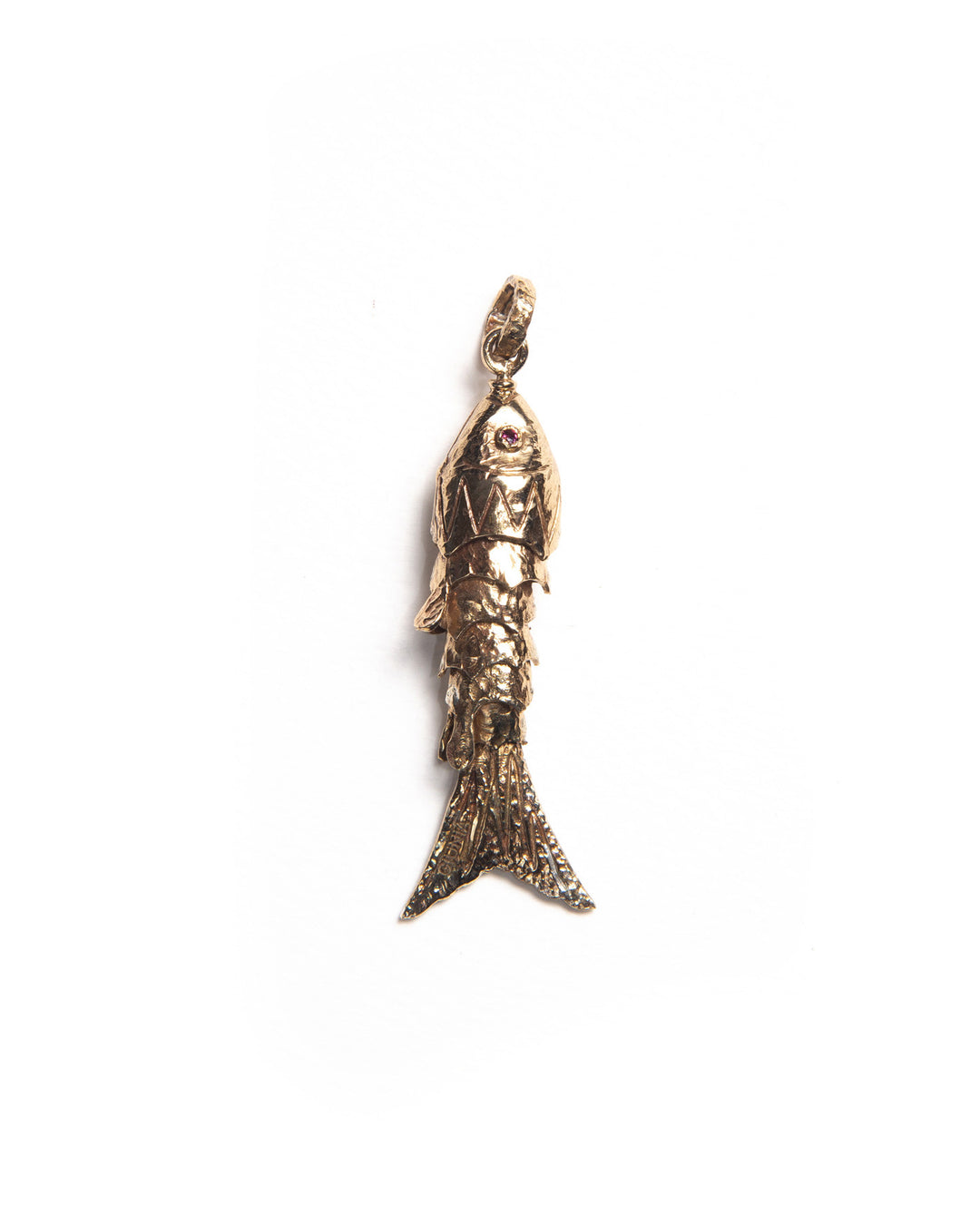 Bronze fish-shaped charm with textured finish and natural gemstone eyes, reflecting light through its layered silhouette. 