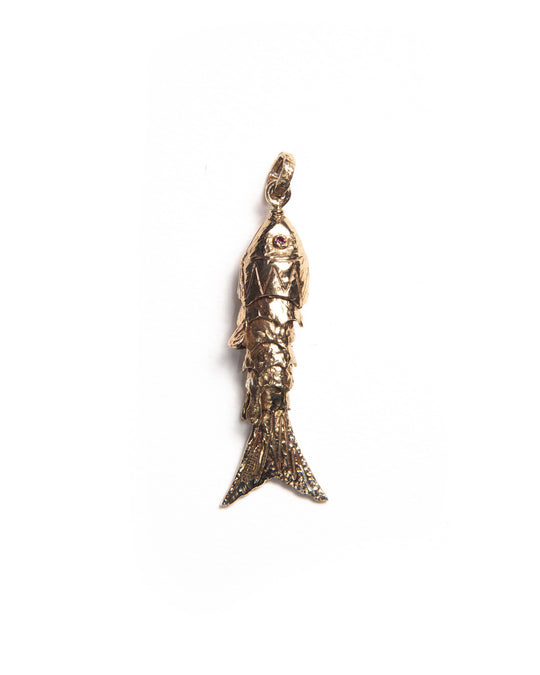 Bronze fish-shaped charm with textured finish and natural gemstone eyes, reflecting light through its layered silhouette. 