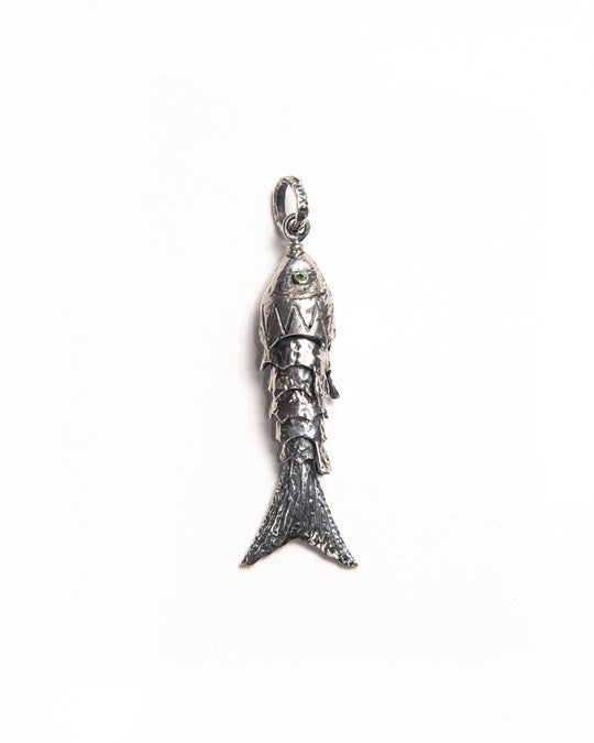 Silver maritime-inspired pendant with textured scales, peridot gemstone eyes, and a movable silhouette, designed to adorn a necklace or earring.
