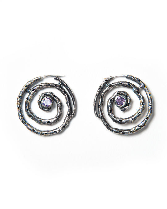 A pair of silver hoop earrings with a textured finish and purple amethyst stones, crafted in Italy.