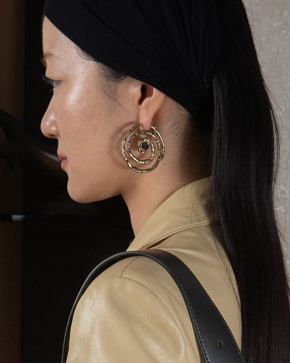 spiral shaped intricate earring on sophisticated woman
