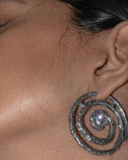 detailed view of the spiral earring with a delicate lilac gemstone sparkling